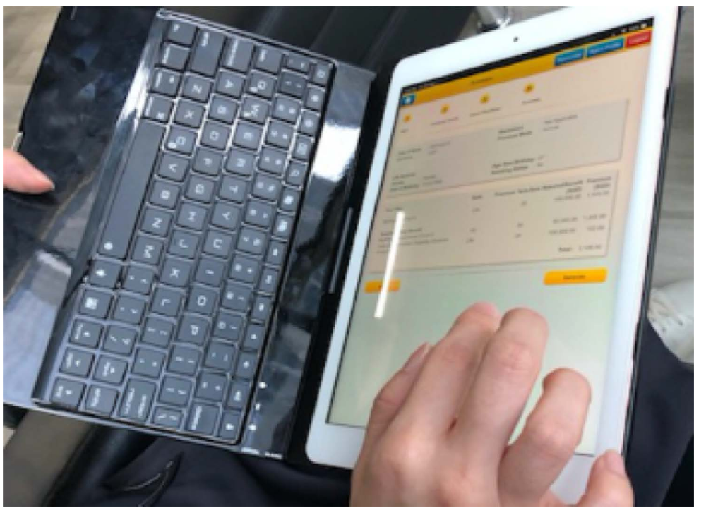 Contextual inquiry: a close-up of a financial advisor's hands working on a tablet with a keyboard, using the real planning tool during an observed session.